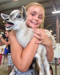 little girl hugging goat